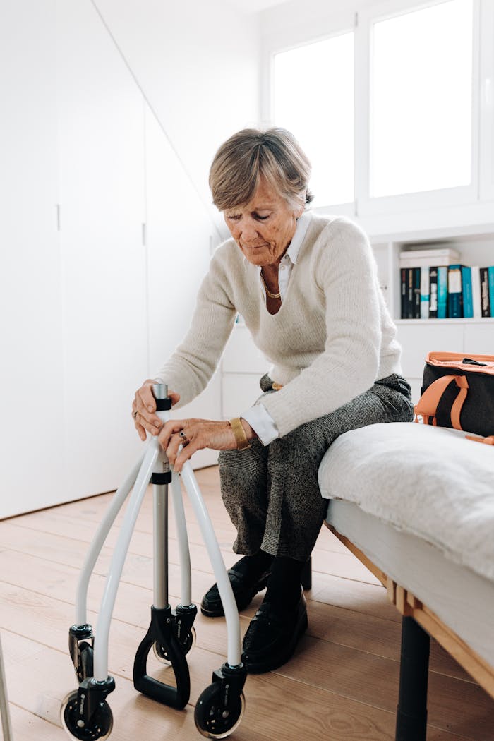 Elderly woman adjusting rollator in a bright, cozy room.